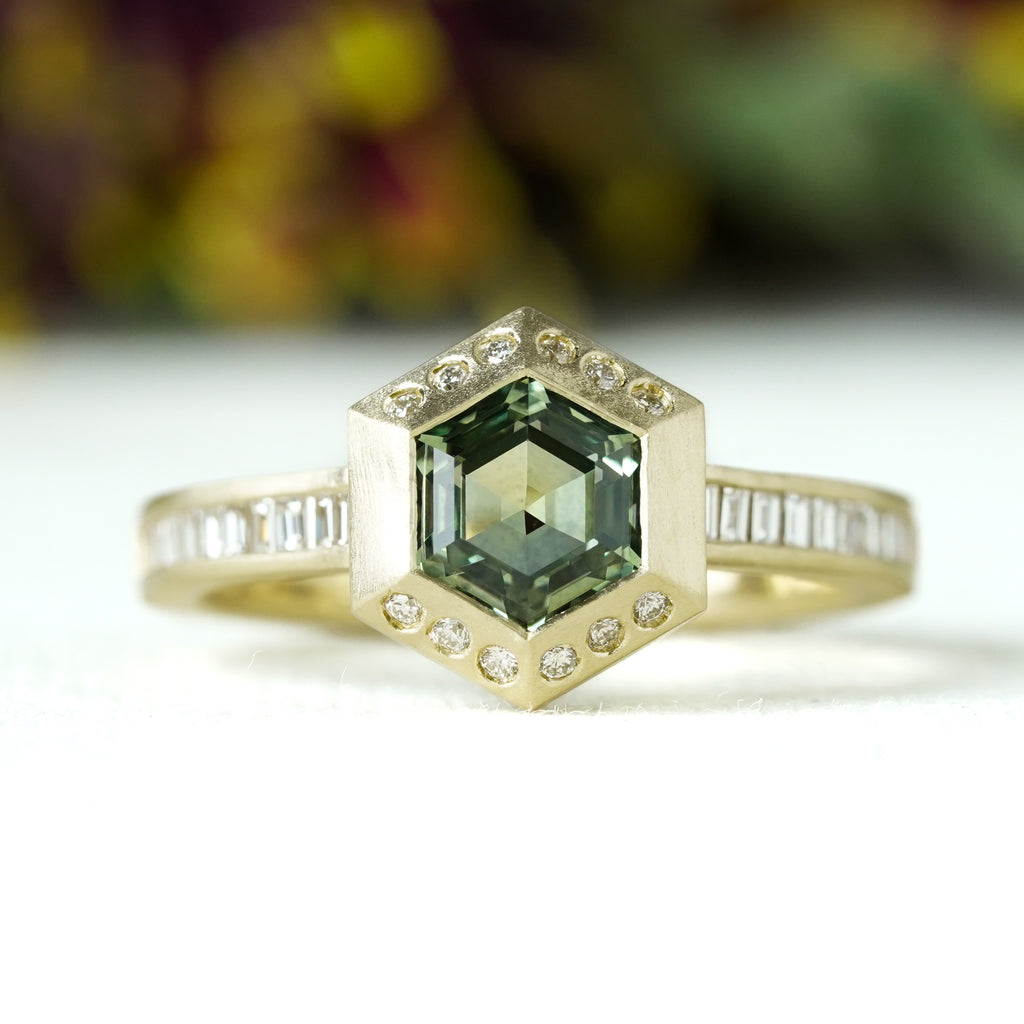 Green hexagon sapphire with half diamond halo in architectural setting