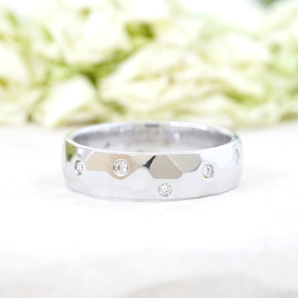 Scattered diamonds in a faceted wide white gold band 