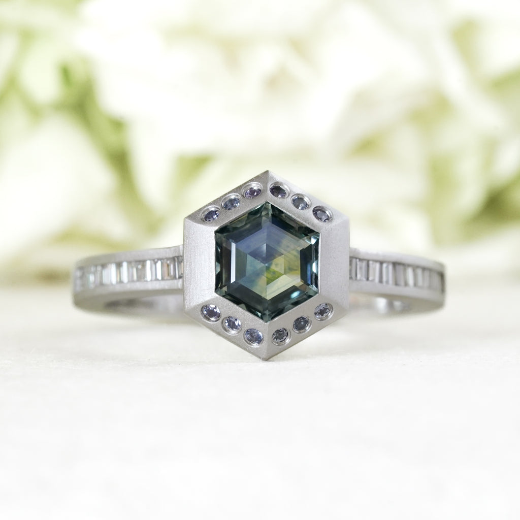 Blue Sapphire Hexagon with diamond half bezel in platinum w/channel set diamonds down the side