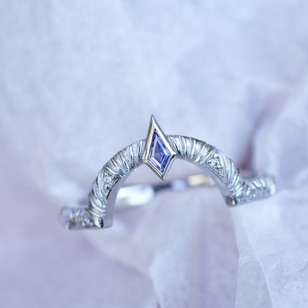 Contour wedding band with round white diamonds and blue sapphire