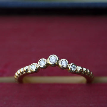 beaded contour wedding band in 14k gold with graduated bezel set diamonds 