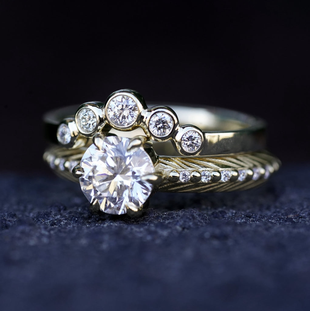 boho engagement ring with diamond and feather pattern with a round diamond contour band on top
