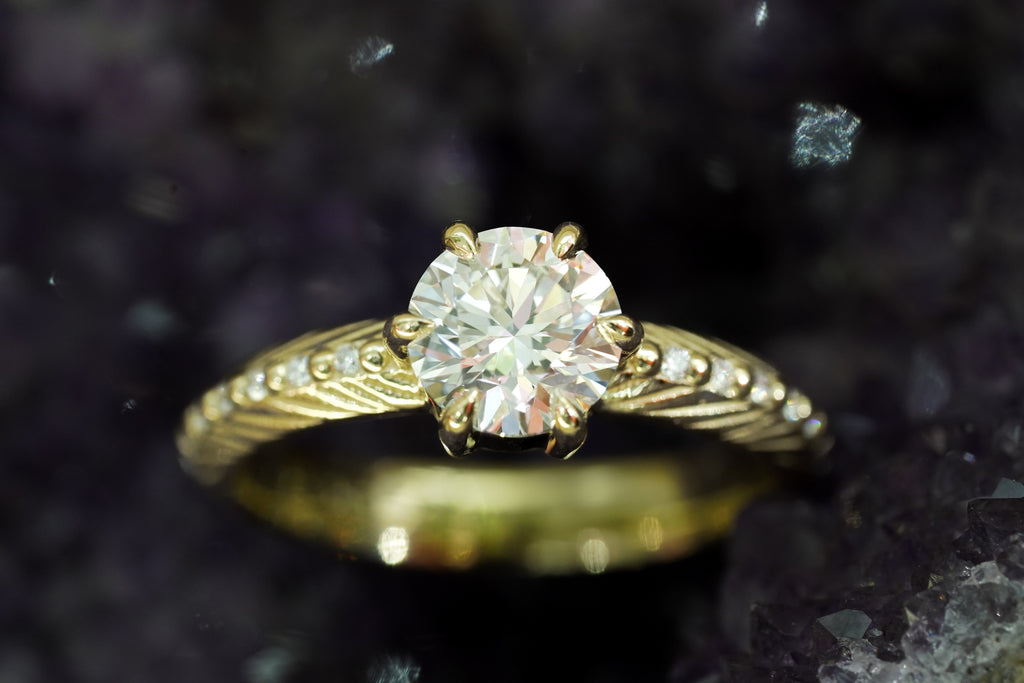 Brilliant cut white lab diamond prong set in yellow gold with feather and diamond detail for the boho bride