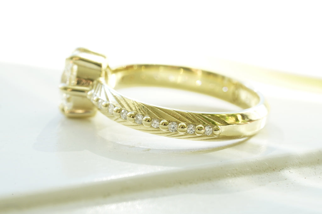 Brilliant cut white lab diamond prong set in yellow gold with feather and diamond detail for the boho bride
