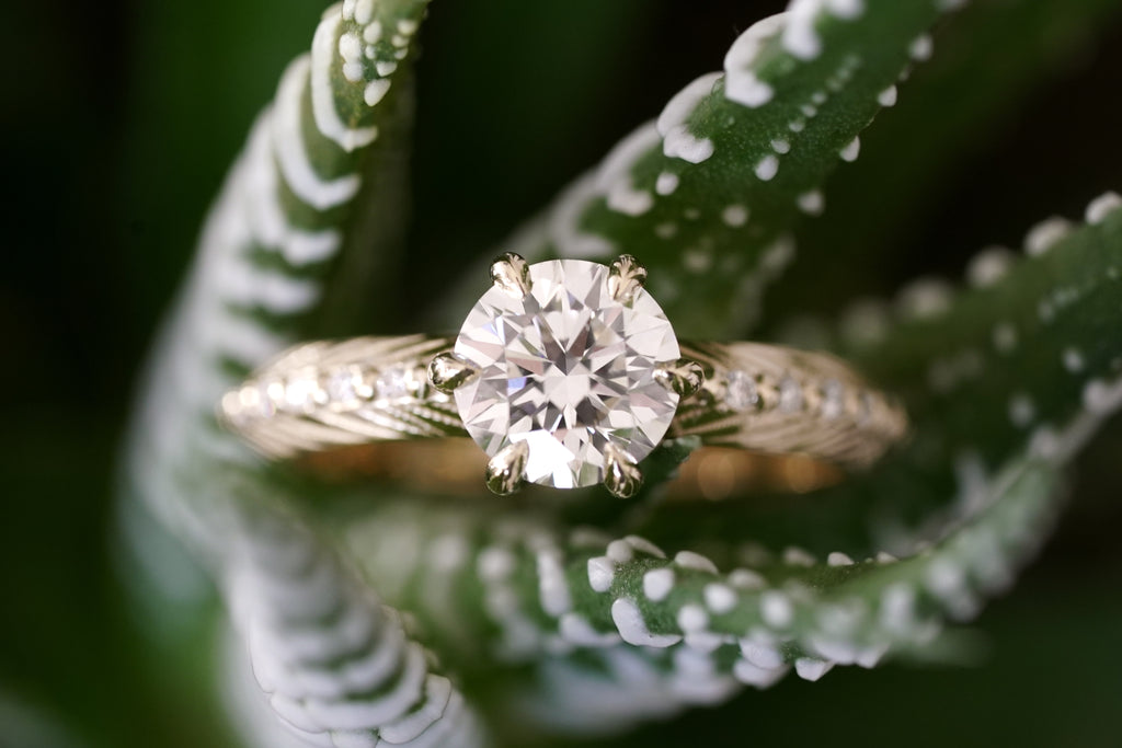 Brilliant cut white lab diamond prong set in yellow gold with feather and diamond detail for the boho bride
