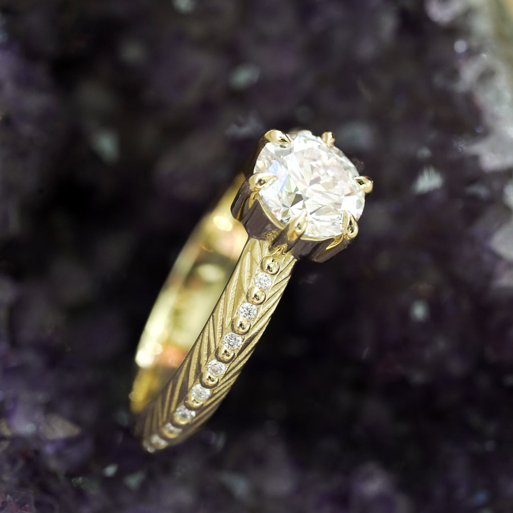 Brilliant cut white lab diamond prong set in yellow gold with feather and diamond detail for the boho bride